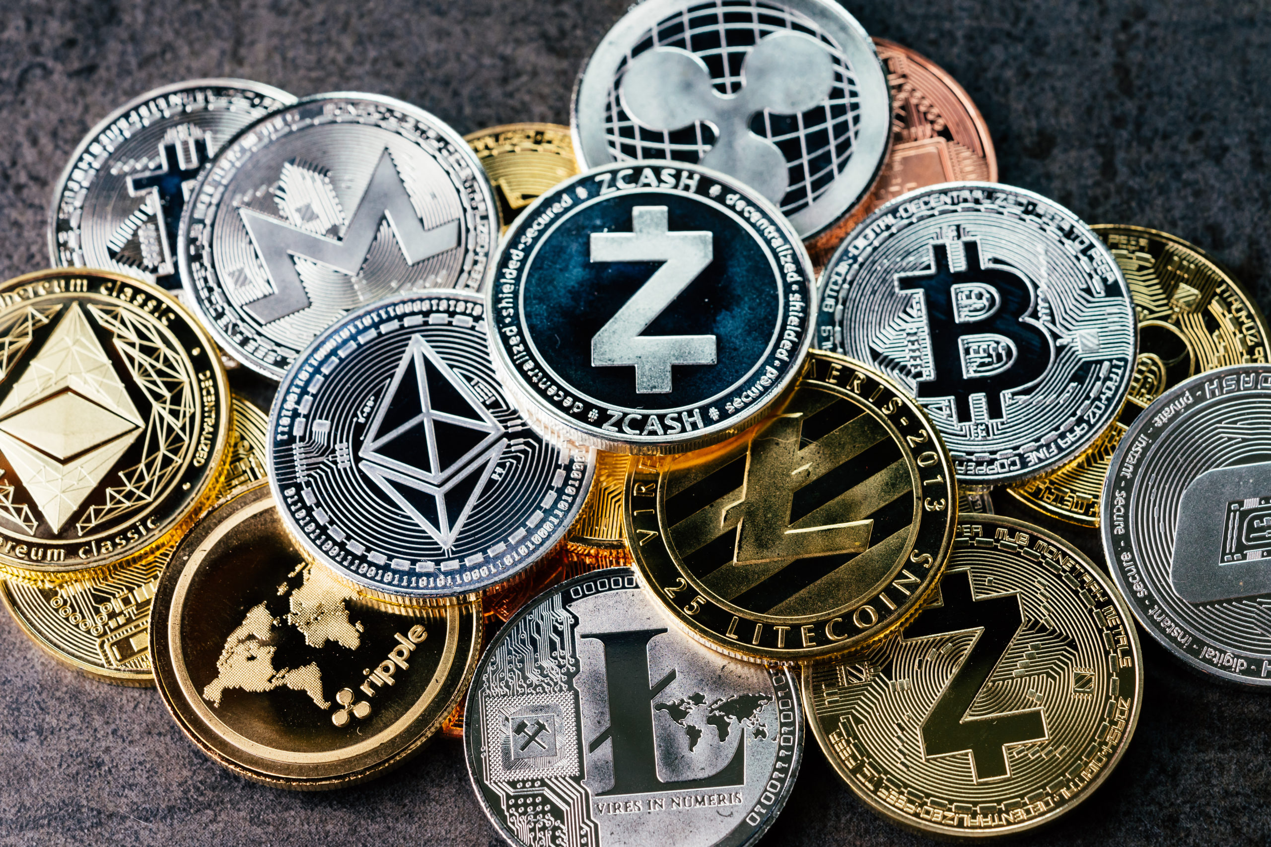 Crypto currency background with various of shiny silver and golden physical cryptocurrencies symbol coins, Bitcoin, Ethereum, Litecoin, zcash, ripple